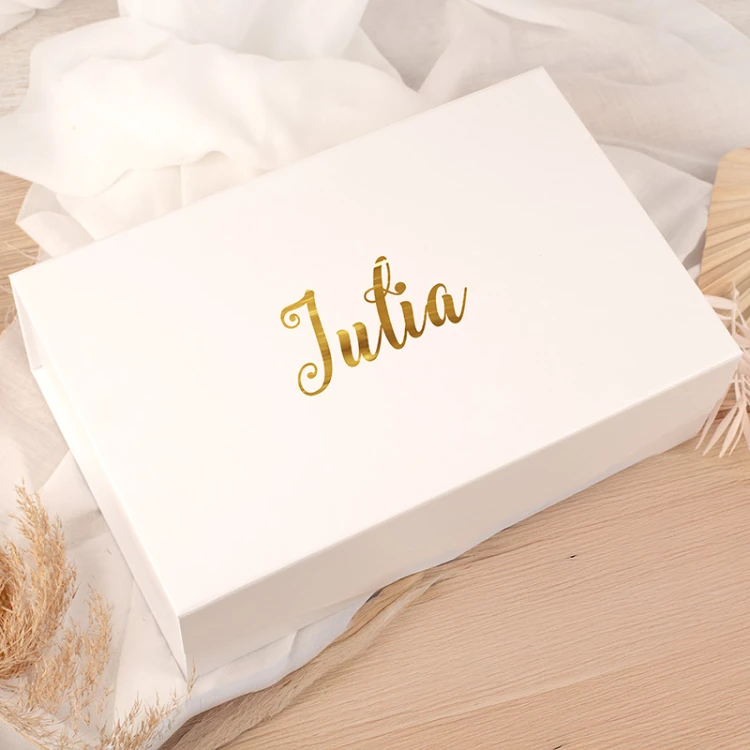 Eleganckie białe pudełko prezentowe z personalizowanym złotym napisem na wieczku.