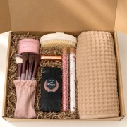 Otwarty świąteczny box prezentowy z akcesoriami do pielęgnacji, kawą i ręcznikiem waflowym.