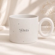 Biały ceramiczny kubek z delikatnym nakrapianym wzorem i personalizacją imieniem.