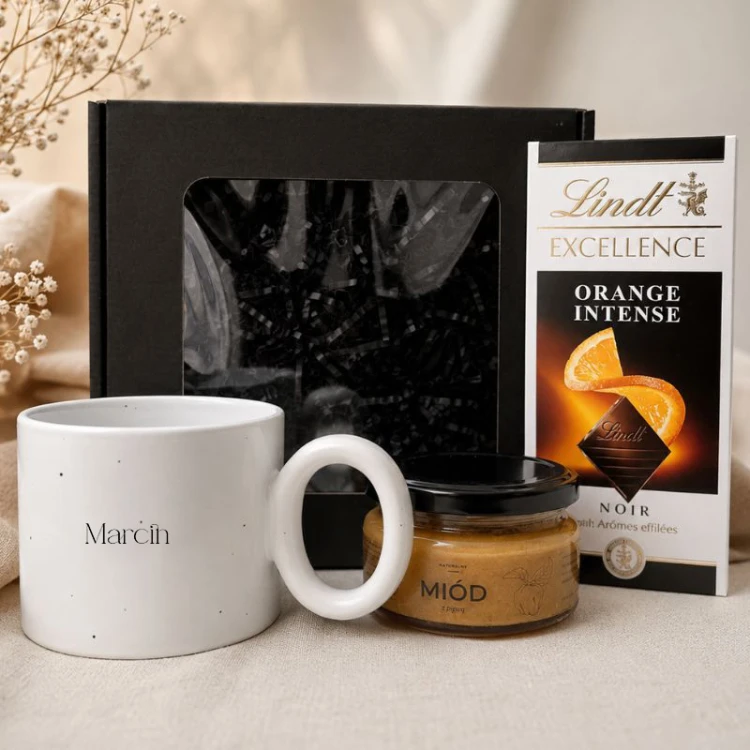 Elegancki zestaw prezentowy dla mężczyzny zawiera duży kubek z imieniem, miód oraz czekoladę Lindt.