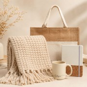 PREMIUM zestaw świąteczny dla kobiety zawiera lnianą torbę, beżowy koc, ceramiczny kubek i notatnik z korkową okładką.