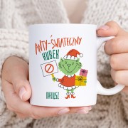 Biały kubek z napisem „Anty-Świąteczny Kubek” posiada kolorową grafikę i personalizację wybranym imieniem.