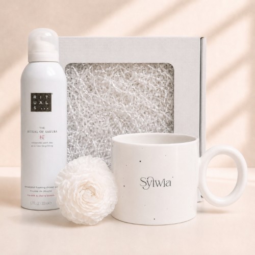 Zestaw prezentowy dla kobiety z personalizowanym kubkiem, pianką Rituals Sakura i świecą w kształcie róży.