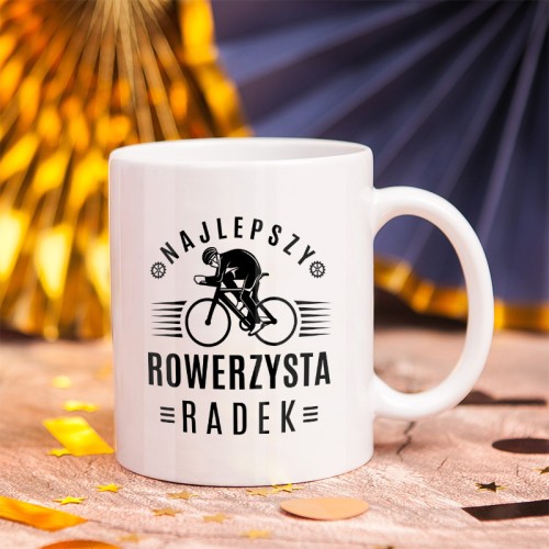 Biały kubek z grafiką kolarza i napisem „Najlepszy Rowerzysta” to prezent dla fana jazdy na rowerze.