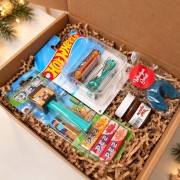 Świąteczny box prezentowy dla dziecka zawiera dwa autka Hot Wheels, dozownik ze słodyczami, Nutellę i niebieskie ciasteczko z wróżbą.
