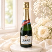 Bezalkoholowe wino musujące Henkell 200 ml w mini butelce ustawione na jasnej podstawce w eleganckiej kremowej aranżacji.