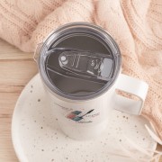 Biały kubek termiczny dla makijażystki z przezroczystą pokrywką i przesuwanym zamknięciem, widok z góry.