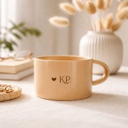 Personalizowany beżowy kubek z inicjałami.