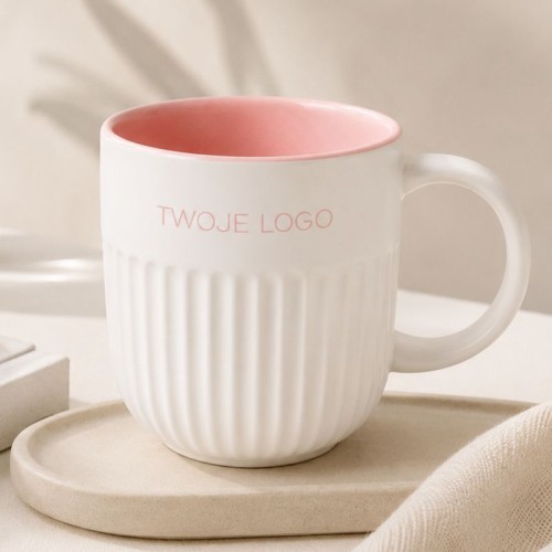 Ceramiczny kubek z ryflowaniem i różowym wnętrzem z logo firmy.